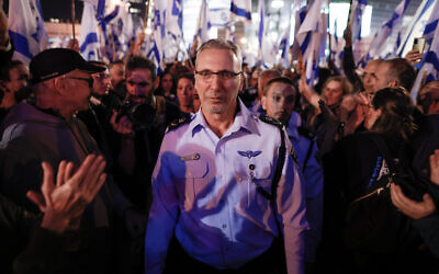 Tel Aviv District Chief of Police Amichai Eshed is greeted by protesters during a rally against the government's judicial overhaul in Tel Aviv on March 11, 2023. (Erik Marmor/ Flash90)