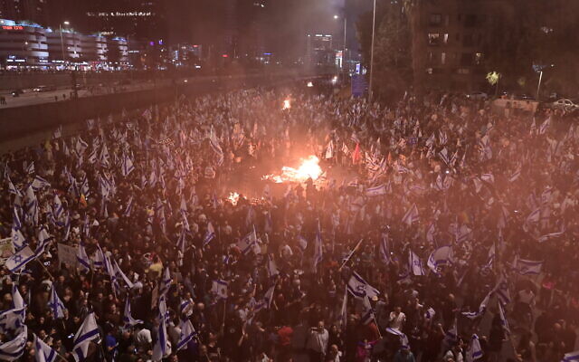 Israelis opposed to Prime Minister Benjamin Netanyahu's judicial overhaul set up bonfires and block a highway during a protest moments after the Israeli leader fired his defense minister, in Tel Aviv, Israel, March 26, 2023. (Tomer Neuberg/Flash90)