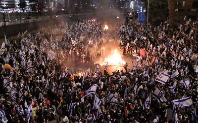 Israelis opposed to Prime Minister Benjamin Netanyahu's judicial overhaul plan set up bonfires and block a highway during a protest moments after he fired Defense Minister Yoav Gallant, in Tel Aviv, March 26, 2023. (Tomer Neuberg/Flash90)