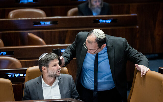 MK Simcha Rotman (right), chair of the Knesset's Constitution, Law and Justice Committee and Finance Minister Bezalel Smotrich seen at the Knesset plenum, in Jerusalem, on March 27, 2023. (Yonatan Sindel/Flash90)