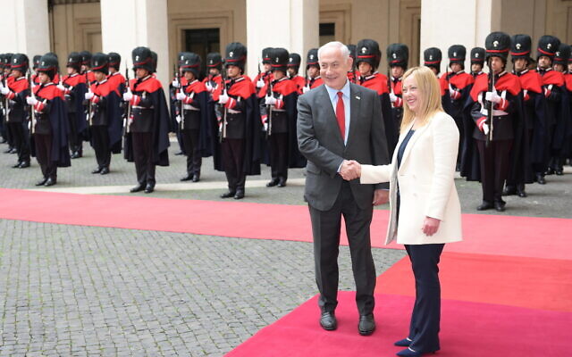 Prime Minister Benjamin Netanyahu shakes hands with Italy's PM Giorgia Meloni (L) in front of an honor guard in Rome's Palazzo Chigi, March 10, 2023 (Amos Ben-Gershom/GPO)