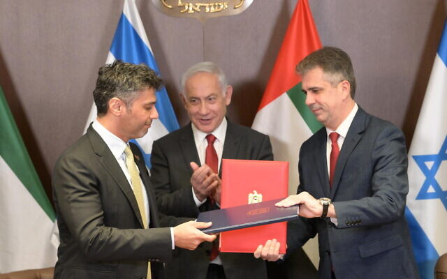 In this handout phot, Prime Minister Benjamin Netanyahu applauds as Foreign Minister Eli Cohen and UAE Ambassador to Israel Mohamed al-Khaja exchange signed copies of the custom agreement between the countries, March 26, 2023. (Amos Ben Gershom/GPO)