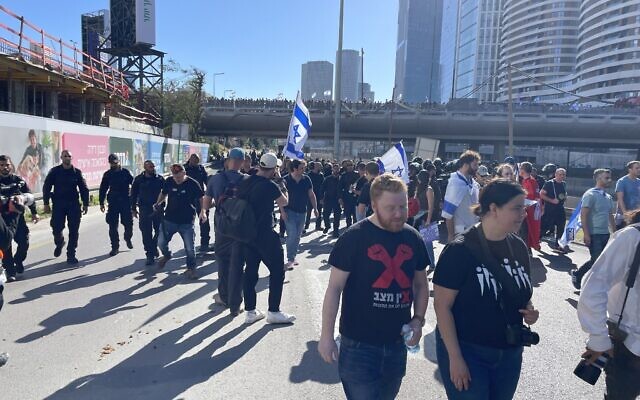 Protesters walk away from a rally blocking the Ayalon Highway in Tel Aviv on March 9, 2023. (Carrie Keller Lynn/Times of Israel)