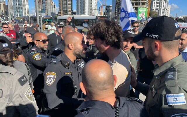 A protester shouts at Israel Police officer Meir Suissa (left), who threw a stun grenade at a Tel Aviv rally, on March 9, 2023. (Carrie Keller Lynn/Times of Israel)