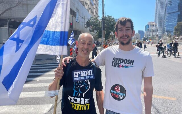 Lior Alon, L, and his son Assaf take part in protests in Tel Aviv on March 16, 2023 (Carrie Keller-Lynn/Times of Israel)