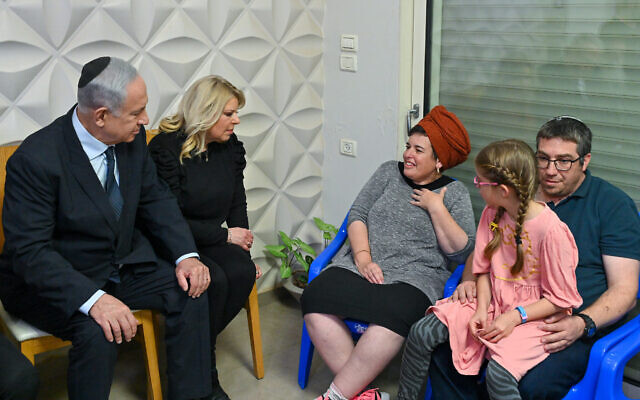 In this handout photo, Prime Minister Benjamin Netanyahu and his wife visit the family of brothers Hallel and Yagel Yaniv, who were killed in a West Bank terror attack, at their home in the Har Bracha settlement, on March 2, 2023. (Kobi Gideon/GPO)