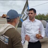Screen capture from video of Communications Minister Shlomo Karhi, center, speaking with protesters outside his home in Moshav Zimrat, March 7, 2023. (Channel 12, Used in accordance with Clause 27a of the Copyright Law)