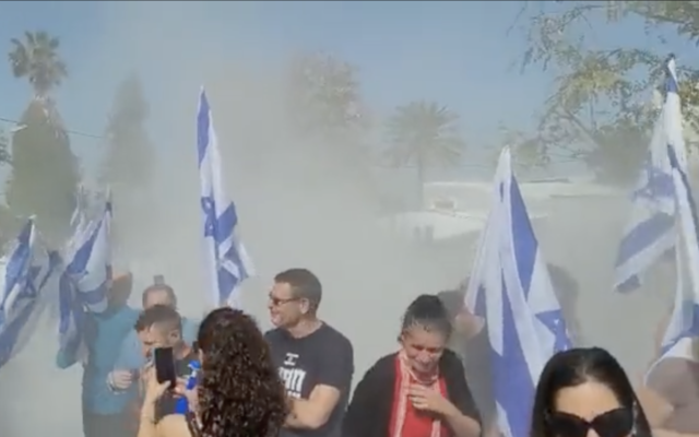 A smoke grenade is thrown toward protesters demonstrating against National Security Minister Itamar Ben Gvir in Kfar Uriah, March 18, 2023 (Screen grab used in accordance with Clause 27a of the Copyright Law)