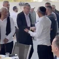 In a screenshot from video, Justice Minister Yariv Levin (center in black jacket) is seen greeting Rafi Chaim-Kedoshim during a Purim party at the latter's home in Herzliya. In the foreground on the right is Energy Minister Israel Katz. (Twitter screenshot; used in accordance with Clause 27a of the Copyright Law)