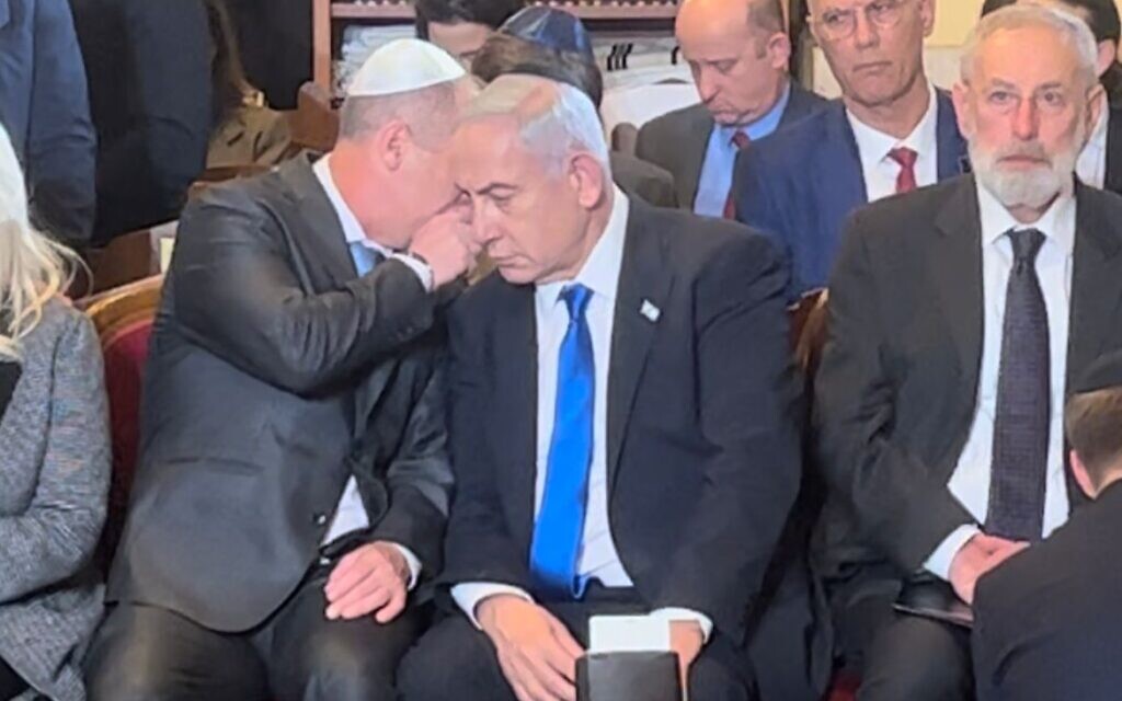 Prime Minister Benjamin Netanyahu being informed of the terror attack in Tel Aviv while in a synagogue in Rome, March 9, 2023. (Lazar Berman/The Times of Israel)