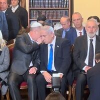 Prime Minister Benjamin Netanyahu being informed of the terror attack in Tel Aviv while in a synagogue in Rome, March 9, 2023. (Lazar Berman/The Times of Israel)