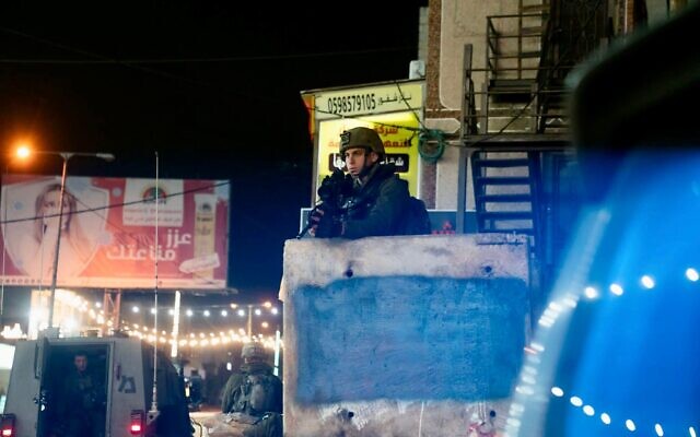 An Israeli soldier stands guard in the West Bank town of Huwara, early March 26, 2023. (Israel Defense Forces)
