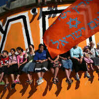 Youths sits on a water tank painted orange, the color symbolizing the movement opposing the disengagement, at the West Bank settlement of Homesh, 12 June 2007 (MENAHEM KAHANA / AFP)
