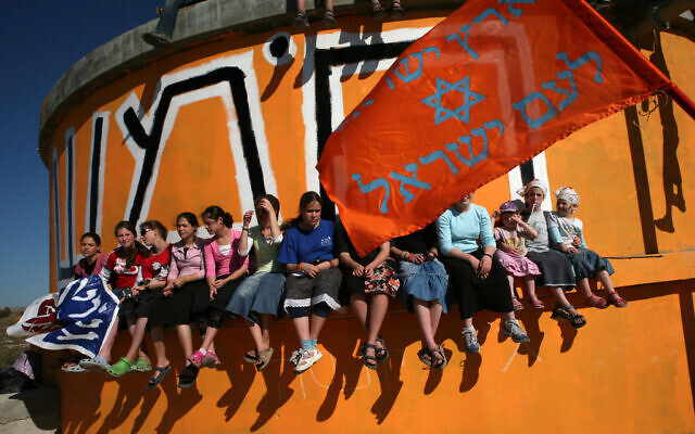 Youths sits on a water tank painted orange, the color symbolizing the movement opposing the disengagement, at the West Bank settlement of Homesh, 12 June 2007 (MENAHEM KAHANA / AFP)