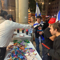 Locals handing out snacks and water to protesters against Israel's judicial overhaul on March 23, in Bnei Brak, Israel. (Haim Uzan)