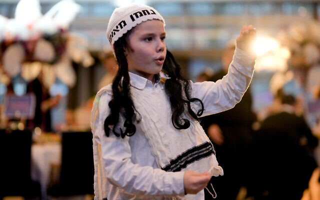 A boy dances to celebrate Purim at a party in a hotel in Berlin, Germany, March 7, 2023. (AP/Markus Schreiber)