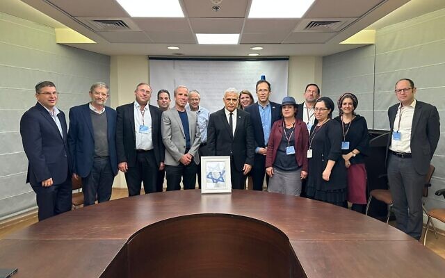 Opposition leader Yair Lapid (C) meets with representatives of the national religious community at the Knesset in Jerusalem on March 13, 2023 (Courtesy Yesh Atid)