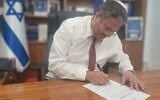 National Security Minister Itamar Ben Gvir signs an order to shutter the Jerusalem office of the Voice of Palestine radio station on March 20, 2023. (National Security Ministry)