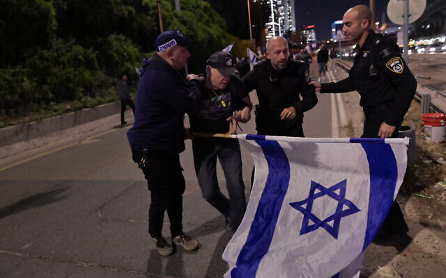 Police and a protester near the Ayalon Highway in Tel Aviv, March 27, 2023. (Tomer Neuberg/Flash90)