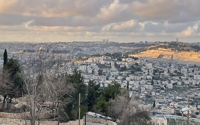 View from Mitzpe-Tel in southeast Jerusalem so the Temple Mount (on the left) and Mount of Olives (lit up by the setting sun), March 6, 2023. (Sue Surkes/Times of Israel)