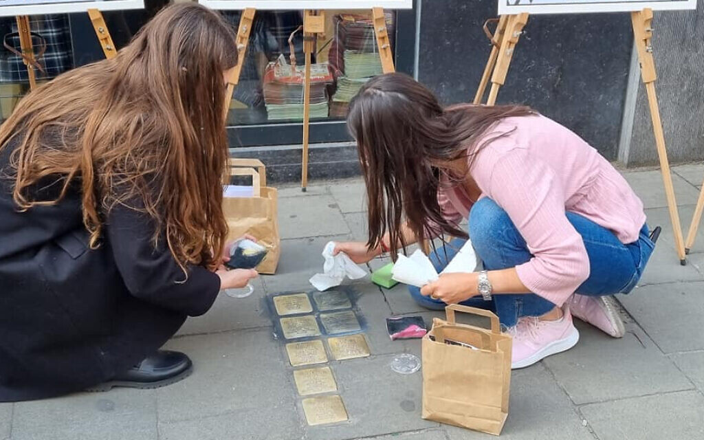 Volunteers clean Stolpersteine (stumbling stones) in Brussels, Belgium, during a Yom Hashoah Stolpersteine cleaning event co-organized with the European Jewish Association, April 27, 2022. (Courtesy of Make Their Memory Shine)
