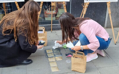 Volunteers clean Stolpersteine (stumbling stones) in Brussels, Belgium, during a Yom Hashoah Stolpersteine cleaning event co-organized with the European Jewish Association, April 27, 2022. (Courtesy of Make Their Memory Shine)