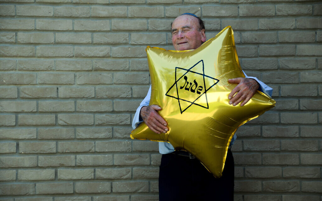 Dugo Leitner, a survivor of Auschwitz-Birkenau, holds a balloon shaped like the Jewish star that the Nazis forced Jews to wear. (Erez Kaganovitz via JTA)