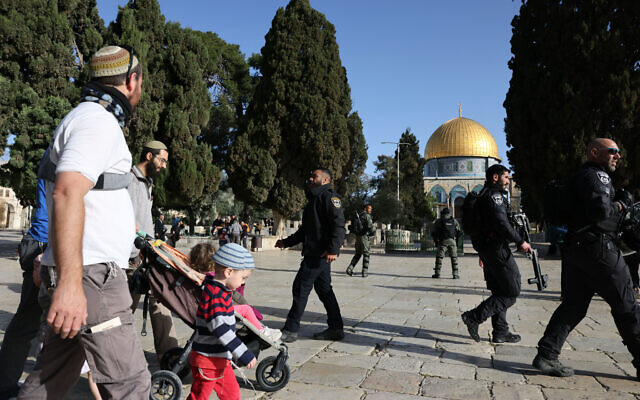 Israeli Jews walk protected by security forces at the Al-Aqsa mosque compound atop the Temple Mount in Jerusalem, early on April 5, 2023 (AHMAD GHARABLI / AFP)