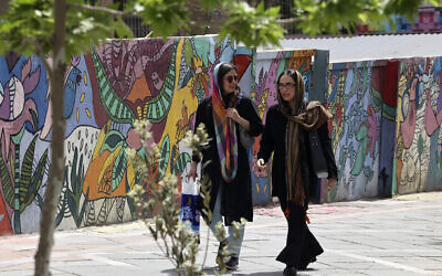 Iranian women, wearing headscarves, walk in a street in Tehran on April 10, 2023. (ATTA KENARE/AFP)