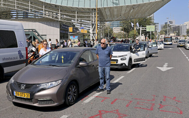 Drivers stand still in Tel Aviv on April 18, 2023 as sirens blare for two minutes marking Israel's annual Holocaust Remembrance Day in memory of the six million Jews killed during World War II. The graffiti reads 'I am afraid'(JACK GUEZ / AFP)