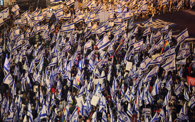 Demonstrators wave flags during a rally to protest the Israeli government's judicial overhaul plans, in Tel Aviv, on April 22, 2023. (JACK GUEZ / AFP)
