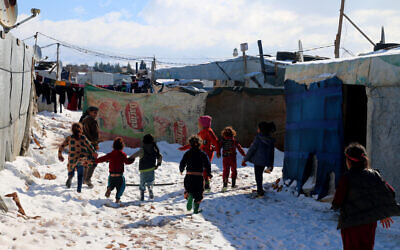 File: Syrian children run through the snow in the Syrian refugee camp of al-Hilal in the village of al-Taybeh near Baalbek in Lebanon's Bekaa valley, on January 20, 2022. (AFP)