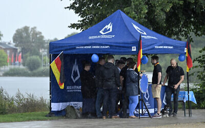 File: People take refuge from rain under a tent of the youth wing of the far-right Alternative for Germany (AfD) party as the AfD meets for the launch of the electoral campaign ahead of the 2021 federal elections, in Schwerin, northern Germany, on August 10, 2021. (John MACDOUGALL/AFP)