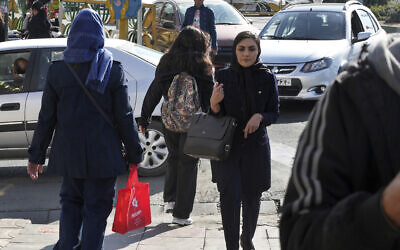 A young Iranian woman crosses a street without wearing her mandatory Islamic headscarf in Tehran, Iran, November 14, 2022. (Vahid Salemi/AP)