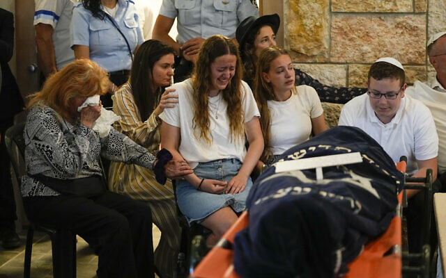 Family members mourn during the funeral of two sisters Maia and Rina Dee, at a cemetery in Kfar Etzion, April 9, 2023. (AP Photo/Ohad Zwigenberg)