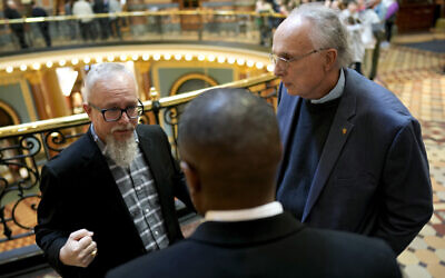 Rev. Mike Demastus, of Des Moines, Iowa, left, and Rev. Bob Curry, of Johnston, Iowa, right, talk with State Rep. Eddie Andrews, center, Thursday, April 6, 2023, at the Statehouse in Des Moines, Iowa. (AP Photo/Charlie Neibergall)