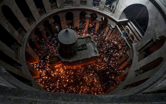 File: Christian pilgrims hold candles as they gather during the ceremony of the Holy Fire at Church of the Holy Sepulchre, Saturday, April 23, 2022 (AP Photo/Tsafrir Abayov, File)