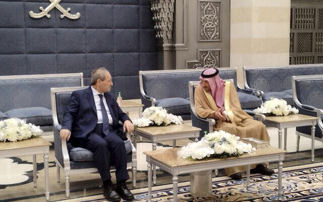 In this photo released by the Syrian official news agency SANA, Saudi Deputy Foreign Minister Waleed Al-Khuraiji, right, meets with Syrian Foreign Minister Faisal Mekdad, upon his arrival at King Abdulaziz International Airport, in Jeddah, Saudi Arabia, Wednesday, April 12, 2023. (SANA via AP)