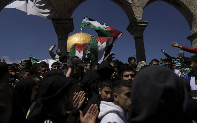 Palestinians wave their national flag and the flag of the Hamas militant group in protest against Israel after midday prayers next to the Dome of Rock at the Al-Aqsa Mosque compound in the Old City of Jerusalem, during the Muslim holy month of Ramadan, Friday, April 14, 2023. (AP Photo/Mahmoud Illean)