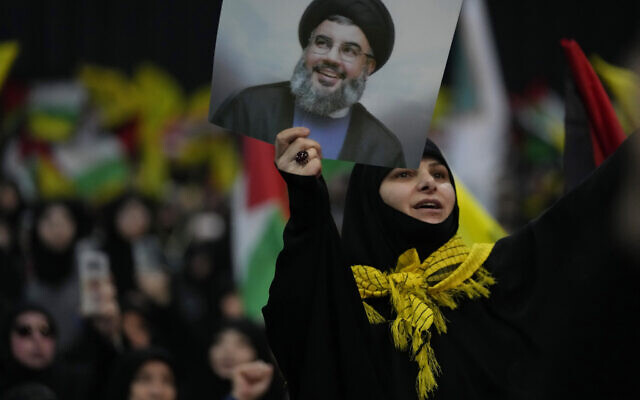 A woman shouts slogans, as she holds a portrait for Hezbollah leader Sayyed Hassan Nasrallah during a rally to mark Jerusalem day, in a southern suburb of Beirut, Lebanon, Friday, April 14, 2023.  (AP Photo/Hussein Malla)