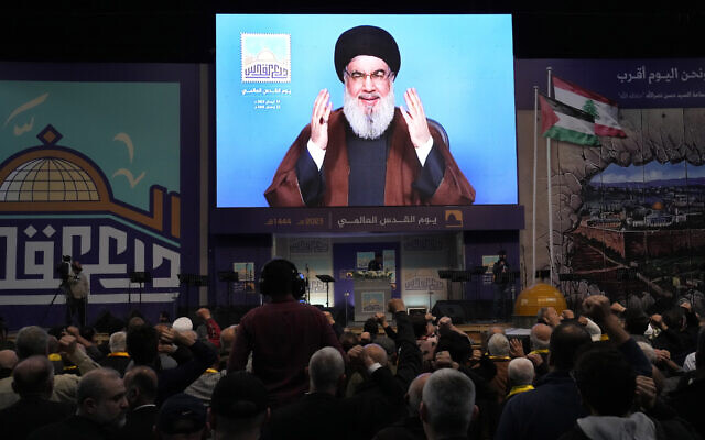 Hezbollah leader Hassan Nasrallah greets his supporters through a screen via a video link from a secret place, during a rally to mark Jerusalem day, in a southern suburb of Beirut, Lebanon, Friday, April 14, 2023. (AP Photo/Hussein Malla)