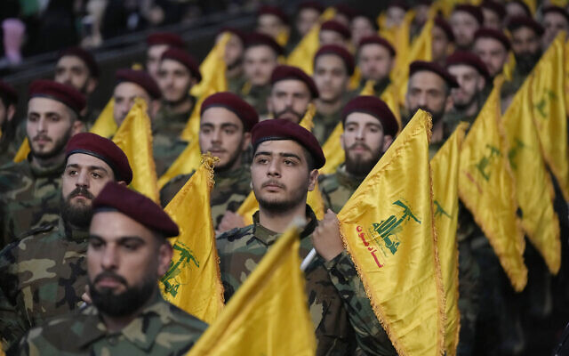 Бойцы «Хезболлы» держат флаги террористической группировки во время парада во время митинга по случаю Дня Иерусалима в южном пригороде Бейрута, Ливан, 14 апреля 2023 года. (AP Photo/Hussein Malla)