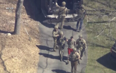 This image made from video provided by WCVB-TV, shows Jack Teixeira, in T-shirt and shorts, being taken into custody by armed tactical agents in Dighton, Massachusetts, on, April 13, 2023. (WCVB-TV via AP)