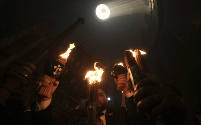 Christian pilgrims hold candles during the Holy Fire ceremony, a day before Easter, at the Church of the Holy Sepulcher, in Jerusalem's Old City, April 15, 2023. (AP Photo/Mahmoud Illean)