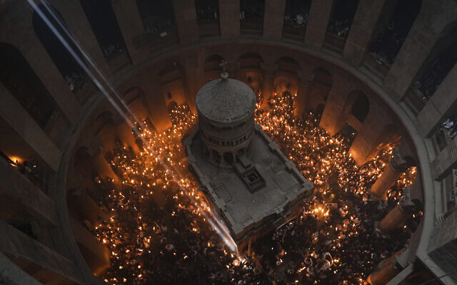 Christian pilgrims hold candles during the Holy Fire ceremony, a day before Easter, at the Church of the Holy Sepulcher, in Jerusalem's Old City, April 15, 2023. (AP Photo/Tsafrir Abayov)