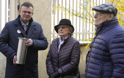 Albert Stankowski, left, the director of the Warsaw Ghetto Museum, Anna Stupnicka-Bando, center, a Polish Christian honored for saving Jews, and Waclaw Kornblum, right, a Polish Holocaust survivor, attend a ceremony for the burial of a 'time capsule' on the grounds of the museum in Warsaw, Poland, on April 18, 2023. (Czarek Sokolowski/AP)