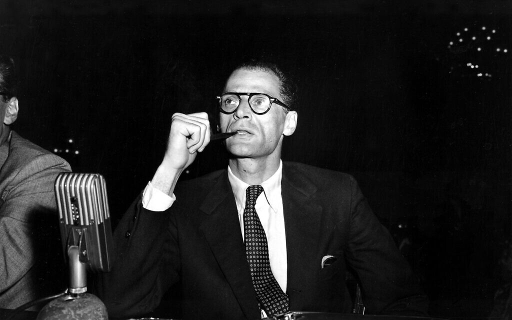 Arthur Miller smokes his pipe at the witness table prior to testifying at a hearing before the House Un-American Activities Committee in Washington, DC, June 21, 1956.  (AP Photo)