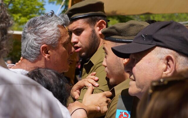 A bereaved family member argues with IDF soldiers at the Beersheba Military Cemetery on Memorial Day, April 25, 2023. (Emanuel Fabian/Times of Israel)