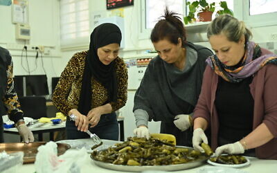 Women prepare dishes for iftar at Ahva primary school in Haifa, on April 13, 2023. (Canaan Lidor/Times of Israel)