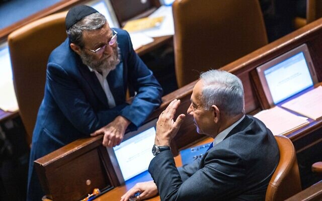 Likud's Benjamin Netanyahu with MK Moshe Gafni  at a vote in the assembly hall of the Knesset on December 28, 2022 (Olivier Fitoussi/Flash90)
